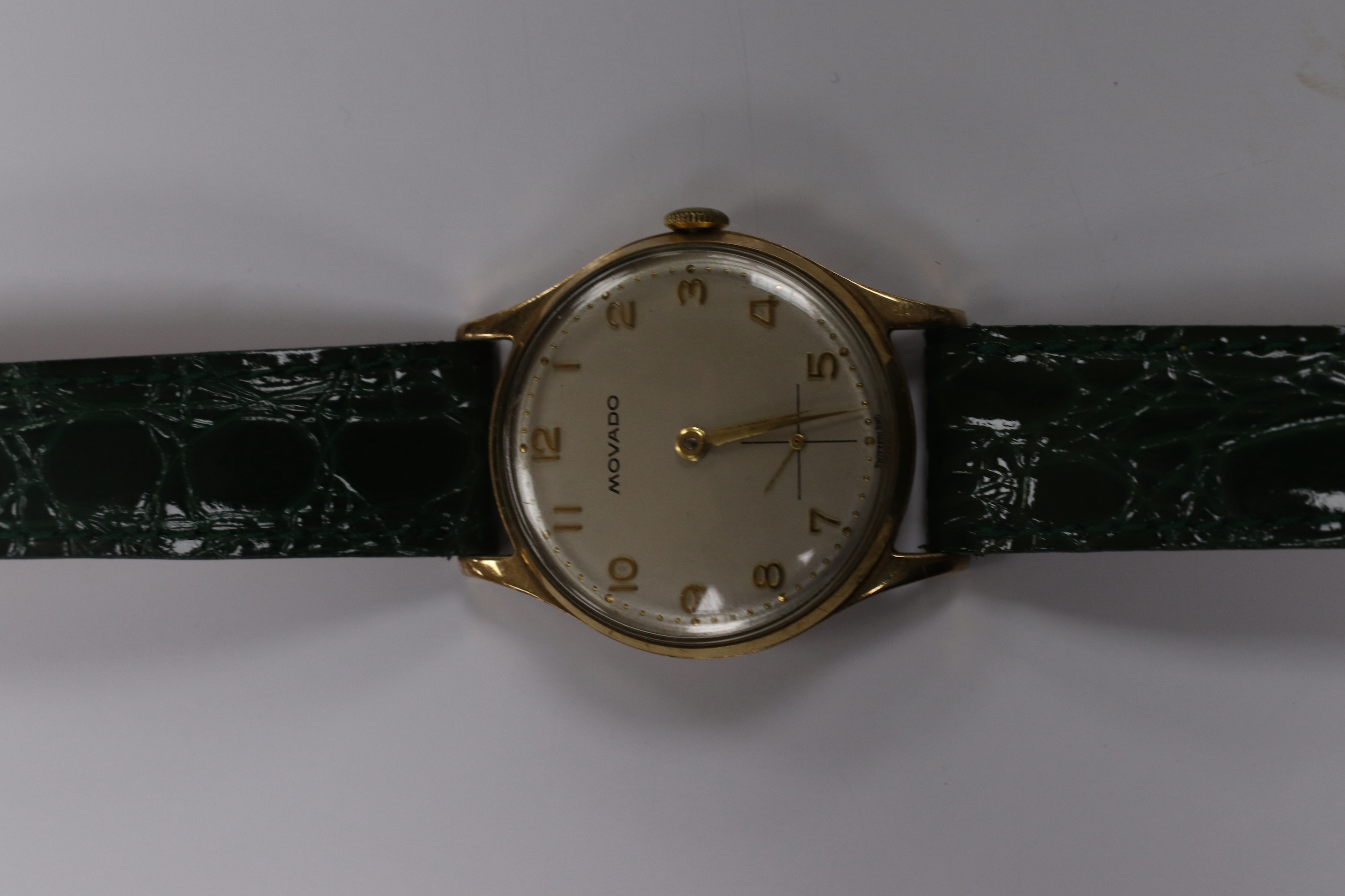 A gentleman's 1950's 9ct gold Movado manual wind wrist watch, with Arabic dial, subsidiary seconds and case back inscription, case diameter 31mm, on a later associated leather strap. Condition - fair